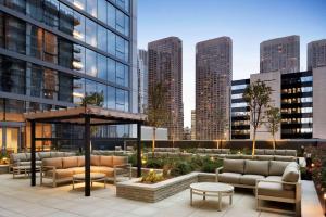 un patio en la azotea con muebles y vistas al perfil urbano en Homewood Suites by Hilton Chicago Downtown West Loop en Chicago