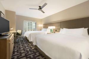 a hotel room with two beds and a flat screen tv at Homewood Suites by Hilton Chicago Downtown West Loop in Chicago