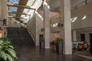 un vestíbulo con escaleras y macetas en un edificio en The Inverness Denver, a Hilton Golf & Spa Resort, en Englewood