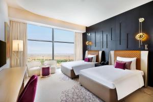 เตียงในห้องที่ AlRayyan Hotel Doha, Curio Collection by Hilton