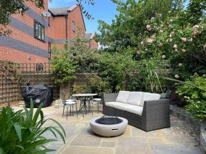 a patio with a couch and a table in a garden at Stylish 1-bed studio in London