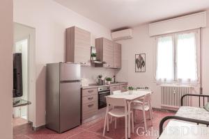 una cucina con tavolo e frigorifero in acciaio inox di Gala158DUE Fair District a Bologna