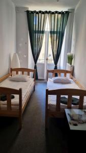 2 Betten in einem Zimmer mit Fenster in der Unterkunft Green Cat Rooms in Krakau