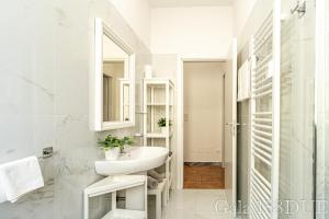 un bagno bianco con lavandino e specchio di Gala158DUE Fair District a Bologna