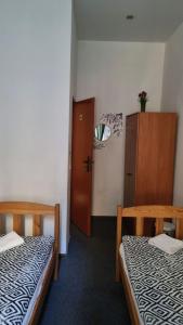 a room with two beds and a cabinet and a door at Green Cat Rooms in Kraków