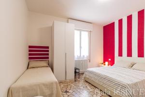 una camera con due letti e strisce rosse e bianche di Gala158DUE Fair District a Bologna