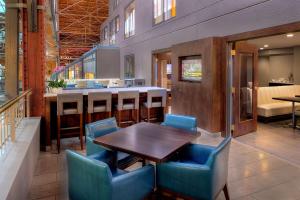 a restaurant with a wooden table and blue chairs at St. Louis Union Station Hotel, Curio Collection by Hilton in Saint Louis