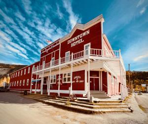 um edifício vermelho e branco com degraus à frente em The Downtown, a Coast Hotel em Dawson City