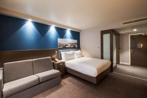 a hotel room with a bed and a couch at Hampton By Hilton Aberdeen Airport in Dyce