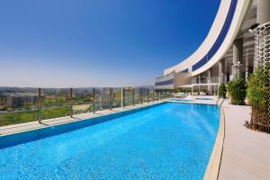 丹吉尔Hilton Tanger City Center的建筑物屋顶上的游泳池