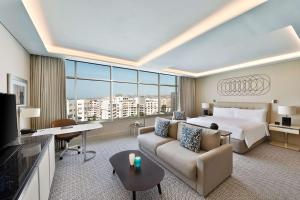 een grote hotelkamer met een bed en een bank bij Hilton Tanger City Center in Tanger