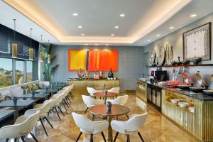 un restaurante con mesas, sillas y una barra en Hilton Tanger City Center Hotel & Residences, en Tánger