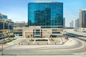 ein großes Glasgebäude mit einer Straße davor in der Unterkunft DoubleTree by Hilton Dubai - Business Bay in Dubai