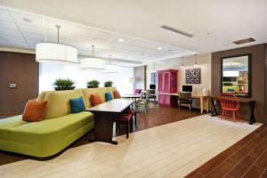 a living room with a green couch and a table at Home2 Suites By Hilton Smyrna Nashville in Smyrna