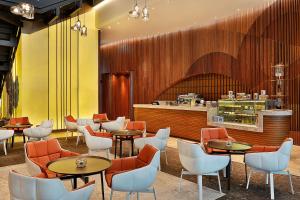 um restaurante com mesas e cadeiras e um balcão em DoubleTree by Hilton Dubai - Business Bay em Dubai