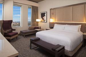 um quarto de hotel com uma cama e uma cadeira em H Hotel Los Angeles, Curio Collection By Hilton em Los Angeles