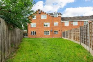 a brick building with a fence in front of it at Free Parking Irlam Flat in Irlam