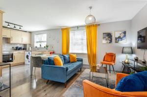 a living room with a blue couch and a kitchen at Free Parking Irlam Flat in Irlam