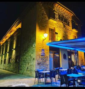 a group of tables and chairs in front of a building at HOSTAL JJ salduero in Salduero