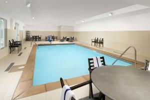 - une grande piscine avec une table et des chaises dans l'établissement Hampton Inn Denver Tech Center South, à Centennial