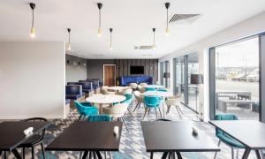 un restaurante con mesas, sillas y ventanas en Hampton By Hilton Humberside Airport, en Kirmington