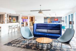 a living room with a blue couch and a table at Hampton By Hilton Humberside Airport in Kirmington