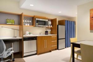 cocina con fregadero y nevera en Home2 Suites By Hilton Joliet Plainfield, en Joliet