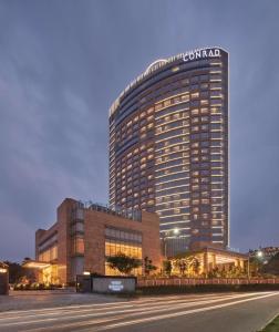 a tall building with a sign on the side of it at Conrad Bengaluru in Bangalore