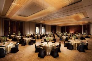 a banquet hall with tables and chairs in a room at Conrad Bengaluru in Bangalore