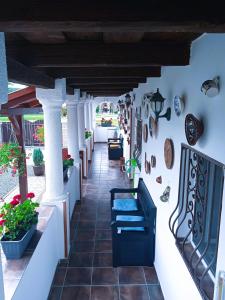 a porch with white columns and plants on the wall at Harmony Vendégház Egerszalók in Egerszalók