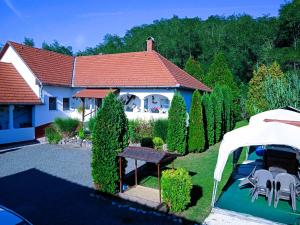 ein Haus mit einem roten Dach und einem Garten in der Unterkunft Harmony Vendégház Egerszalók in Egerszalók