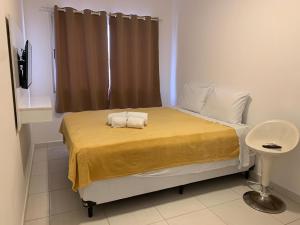 a bedroom with a bed with two towels on it at Flat Itaguai in Itaguaí