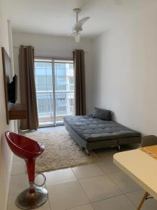 a living room with a bed and a large window at Flat Itaguai in Itaguaí