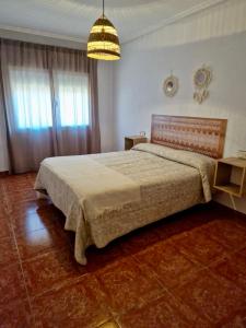 ein Schlafzimmer mit einem Bett und einer Hängeleuchte in der Unterkunft Piso en Jarandilla de la Vera in Jarandilla de la Vera