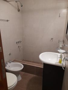 łazienka z umywalką, toaletą i wanną w obiekcie Barracas Charme w BuenosAires