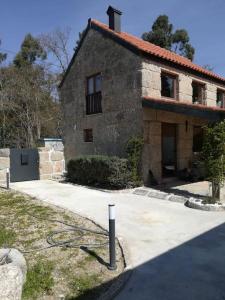 une grande maison en pierre avec un tuyau en face de celle-ci dans l'établissement Beiral da Marfida, à Amarante