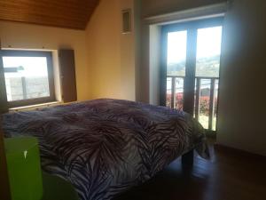 un lit dans une chambre avec une grande fenêtre dans l'établissement Beiral da Marfida, à Amarante