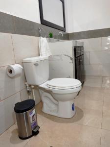 a bathroom with a toilet and a trash can at Este Hotel in Estelí