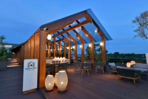 een paviljoen met tafels en stoelen op een terras bij Doubletree By Hilton Weerawila Rajawarna Resort in Weerawila