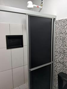 Una puerta negra en un baño con microondas en Alvorada Suite, en Manaus