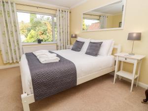 een slaapkamer met een bed met een spiegel en een raam bij Milestones in Wells