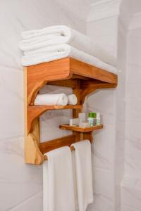 y baño con estante de madera y toallas. en The Glacier Hotel Nanyuki en Nanyuki