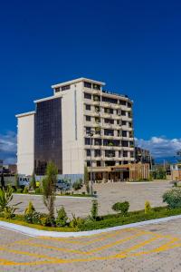 The Glacier Hotel Nanyuki في نانيوكي: مبنى ابيض كبير امام موقف سيارات