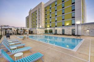 uma piscina do hotel com espreguiçadeiras e um edifício em Home2 Suites By Hilton Plano Richardson em Plano