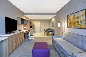 a living room with a couch and a kitchen at Home2 Suites By Hilton Plano Richardson in Plano