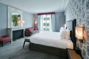 um quarto com uma cama grande e uma lareira em Maison Astor Paris, Curio Collection by Hilton em Paris