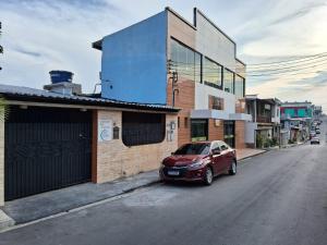 a red car parked on the side of a street at Alvorada Suite in Manaus