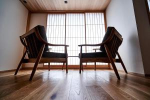 two chairs sitting in front of a large window at Kikokutei Bekkan in Kyoto