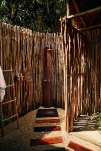 una recinzione in legno con una porta in legno e una scala in legno di Our Habitas Tulum a Tulum