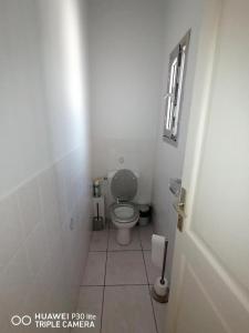 a small bathroom with a toilet and a window at Grande chambre dans villa proche de la plage in Sète